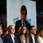 El secretario general de Junts, Jordi Turull (c), escucha la intervención de Carles Puigdemont (en las pantallas) durante el Congreso del partido que se celebra este fin de semana en Calella (Barcelona). EFE/ Quique García