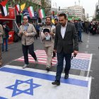 Iraníes caminan sobre banderas de Estados Unidos e Israel durante una manifestación antiestadounidense con motivo del 45 aniversario de la toma de la embajada de Estados Unidos, frente al antiguo edificio de la legación diplomática en Teherán, el 3 de noviembre de 2024. EFE/EPA/ABEDIN TAHERKENAREH