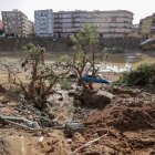 Restos de vehículos arrastrados por la corriente en el barranco del Poyo en Paiporta, Valencia, este lunes.