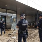 Agente de la Policía Nacional vigilan un comercio en Alfafar (Valencia), este viernes. EFE/ Kai Försterling