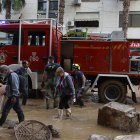 Imagen de archivo de efectivos del cuerpo de Bomberos y voluntarios durante las labores de limpieza en una calle en Catarroja.
                       EFE/J.J. Guillén