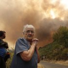 Una vecina se lamenta del fuego a las puertas de su pueblo, en La Cabrera.