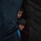Niños palestinos desplazados internamente miran desde dentro de su tienda en un día ventoso en Khan Younis, en el sur de la Franja de Gaza, 24 de noviembre de 2024. 
                       EFE/EPA/HAITHAM IMAD