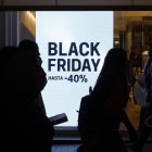 MADRID, 29/11/2024.- Peatones pasan por delante del escaparate de un comercio madrileño que anuncia rebajas por el 'Black Friday' de hasta el -40%. El 'Black Friday', que se celebra este viernes, marca en España el arranque de la temporada más intensa para el comercio minorista, que incluye las fiestas navideñas y las posteriores rebajas, un periodo en el que el sector espera impulsar sus ventas, estancadas en lo que va de año. EFE/ Juanjo Martín