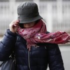 Imagen de archivo de una mujer sujetando su gorro en una jornada de viento. EFE/Jesús Diges