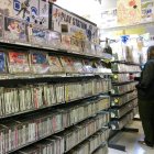Unas personas frente a una estantería con juegos usados de PlayStation a la venta en una tienda de videojuegos retro en Tokio, el 3 de diciembre de 2024. EFE/EPA/CHRISTOPHER JUE