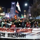 Miembros de la Confederación de Sindicatos de Corea del Sur y grupos cívicos portan una gran pancarta mientras marchan hacia la oficina presidencial durante una manifestación que pide la destitución y juicio político del presidente Yoon Suk-yeol, en Seúl, el 4 de diciembre de 2024. EFE/EPA/JEON HEON-KYUN