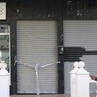 Una persona camina frente a un local precintado por la Policía Nacional en la zona de la localidad de Fuengirola donde han matado a tiros a un hombre, aún por identificar, esta madrugada. EFE/Daniel Pérez