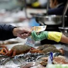 FOTODELDÍA A CORUÑA, 19/12/24.- Un hombre pagael pescado adquirido en uno de los puestos del mercado de la plaza de Lugo, en la ciudad de A Coruña, donde comienza a notarse el incremento de clientes que adelantan las compras de cara a las fiestas de la Navidad, con un "buen ritmo de ventas y producto freso de primera calidad". EFE/Cabalar