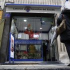 Una persona observa la entrada de una administración de lotería.