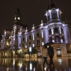 En la imagen una pareja pasea bajo la lluvia por la plaza del Ayuntamiento de Valencia. EFE/Manuel Bruque