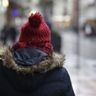 Una persona se protege del frío en la ciudad.