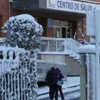 Dos personas entran en el centro de salud de José Aguado, rodeado de nieve.