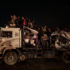 Palestinos desplazados internos viajan durante la noche esperando regresar a sus hogares en el norte de Gaza.