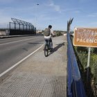 Un ciclista atraviesa el paso superior de Trobajo del Cerecedo sobre las vías.