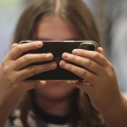 Fotografía de archivo, tomada el 20/10/2023, que muestra a una niña que mira su teléfono móvil en España. EFE/ J.M. García