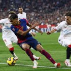 El delantero del FC Barcelona Lamine Yamal (2i)se escapa de la presión de varios jugadores sevillistas durante un encuentro correspondiente a la jornada 23 de LaLiga EA Sports entre el Sevilla FC y el FC Barcelona en el estadioo Ramón Sánchez-Pizjuán de Sevilla. EFE/ Julio Munoz