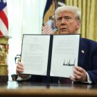 El presidente estadounidense, Donald Trump, sostiene una orden ejecutiva firmada ayer en el Despacho Oval de la Casa Blanca.