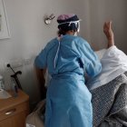 Una trabajadora atiende a un anciano en una residencia durante la pandemia.