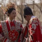 Una pareja con el traje tradicional tras contraer matrimonio ante la ciudad prohibida.