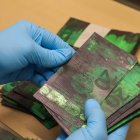 Un trabajador del Área de Operaciones con Efectivo del Banco de Portugal maneja un fajo de billetes de 20 euros manchados de tinta. EFE/Carlos Caselles