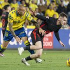 El centrocampista del FC Barcelona, Marc Casadó (d), se lleva el balón ante el delantero de la UD Las Palmas, Sandro Ramírez, durante el encuentro correspondiente a la jornada 25 de Laliga EA Sports que disputaron en el estadio de Gran Canaria. EFE / Quique Curbelo.