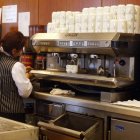 Una mujer atiende una cafetería.