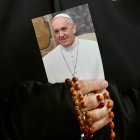 Una monja sostiene una imagen del Papa Francisco y un rosario mientras los fieles asisten a una oración del Rosario por la salud del pontífice en la Plaza de San Pedro este lunes, en la Ciudad del Vaticano. EFE/EPA/ALESSANDRO DI MEO