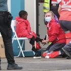 Un grupo de personas migrantes, entre ellos varios menores, es atendido por la Cruz Roja.