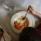 Un menor come arroz en un restaurante.