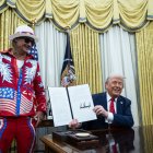 Trump firma una orden ejecutiva junto al cantante Kid Rock en el despacho Oval de la Casa Blanca.