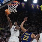 El base dominicano del Real Madrid Andrés Feliz (i) entra a canasta ante el alero estadounidense del FC Barcelona Jabari Parker (c) durante el encuentro correspondiente a la fase regular de la Liga Endesa que disputaron en el Palau Blaugrana de Barcelona. EFE / Alejandro García.