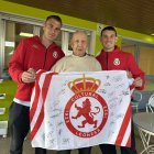 Matías Mata, flanqueado por los jugadores de la Cultural Miguel Bañuz y Santi Samanes con una bandera de la Cultural firmada por toda la plantilla.  Matías Mata posa al lado del actual entrenador de la Cultural, Raúl Llona.