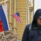 Un hombre pasea cerca de las banderas de Rusia y EEUU en Moscú.