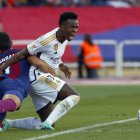 Vinícius Júnior (d) delantero brasileño del Real Madrid disputa una acción ante Ferrán Torres en el Estadio Olímpico Lluís Companys de Barcelona en foto de archivo de Quique Garcia. EFE