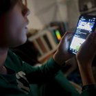 Un joven interacciona a través de un teléfono móvil.