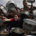 Palestinos desplazados internamente se agrupan en una fila para recibir una ración de comida de una cocina benéfica, en Khan Younis, sur de la Franja de Gaza, 11 de abril de 2025. EFE/EPA/HAITHAM IMAD