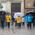 Un grupo de turistas escuchaba ayer a uno de los guías de León, en medio de la lluvia y la nieve.