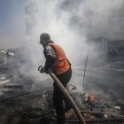 Un trabajador de la defensa civil palestina apaga el fuego de una tienda de campaña tras un ataque israelí el 21 de abril de 2025. EFE/EPA/MOHAMMED SABER