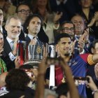 Los jugadores del FC Barcelona, el uruguayo Ronald Araujo (d) y el alemán Marc-André ter Stegen, reciben el trofeo de campeones de manos del rey Felipe.