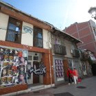 Edificios en ruinas de la plaza de San Pedro en Ponferrada, convertidos en tablones de anuncios.  La calle Comendador en 2023, con una ruina vallada tras el desplome de la casa.
