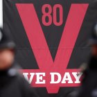 Policías británicos ante un cartel del Día de la Victoria antes del desfile militar para conmemorar el 80 aniversario del fin de la II Guerra Mundial, en Londres, el 5 de mayo de 2025. EFE/EPA/ANDY RAIN
