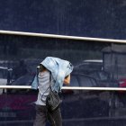 Una mujer sse protege de la lluvia.