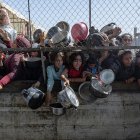 Palestinos desplazados se agolpan frente a un comedor social para recibir raciones de alimentos al sur de la Franja de Gaza. EFE/ Haitham Imad.