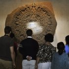 Visitantes del Museo Nacional de Antropología de México contemplan la piedra del Sol.