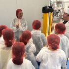 La consejera de Agricultura charla con alumnos en la visita a una fábrica.