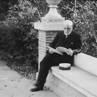 Santiago Ramón y Cajal sentado en un banco mientras lee.