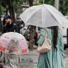 Archivo - Una mujer y un niño pasean con un paraguas.