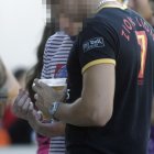 Dos jóvenes durante un botellón consumen cerveza.