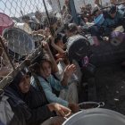 Palestinos buscan comida en las 'colas del hambre'.